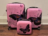 Group shot showing all three pink hardshell cases with butterfly graphics