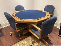 Four chairs arranged around octagonal poker table showing felt top and table frame