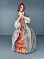 Front view of the full figurine showing gown, bonnet, and posture