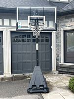 Front view of assembled portable basketball system showing base, pole, backboard, net and wheels