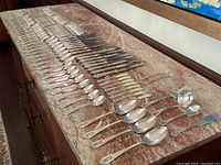 Full spread of all flatware pieces on marble top showing complete layout