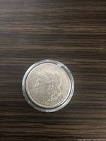 Obverse side of the 1880 Morgan Silver Dollar coin showing Lady Liberty's profile in airtite.