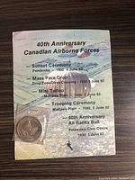 Coin in plastic casing shown alongside original backing card listing events for the 40th anniversary of the Canadian Airborne Forces held in June 1982.