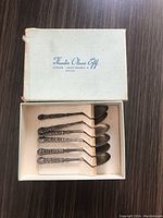 Set of six intricately designed silver spoons in original fabric-lined box