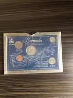 Front view of Bermuda coin set mounted on blue card with map and coin denomination details, showing five coins.