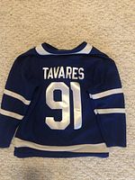 Back view of blue kids hockey jersey with TAVARES and number 91 in white lettering.