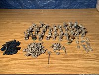 Overall layout of various painted and unpainted RAFM and Warhammer 40K miniatures, several piles of separate arms and bits including a painted Eldar Falcon Grav Tank vehicle.