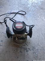 Top angled view of electric router showing handles, power cord, and body condition.