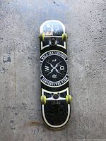 Bottom side of skateboard with World Skateboards graphic, trucks and yellow wheels visible.