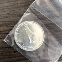 Obverse side showing a howling wolf, the denomination 50 cents, and the dates 1867-1967, indicating a sesquicentennial edition coin.