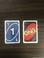 Two UNO decks displayed with blue and black/red cards visible, both sealed in original packaging.