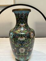 Front and full view of the cloisonne vase showing colorful floral and swirl patterns with black background