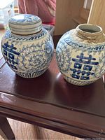 Both ginger jars side by side on wood surface