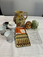 Photo showing all items together including vase, cups, candle holder, bowl, elephant and pig figurines, glass dish and cocktail fork set