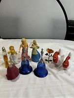 Full view of the collection of vintage perfume bottles and decorative figurines shown on a white surface.