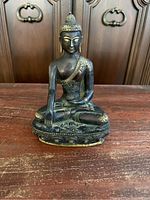 Front view of seated Buddha statue on lotus pedestal