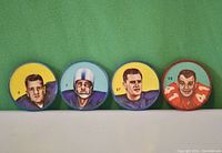 Front view of four CFL player coins lined up showing colorful illustrated portraits and jersey numbers.