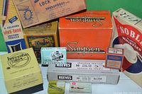 Boxes arranged grouped with visible brands and labels including Simpson Instrument, Shakeproof Lock Washers, Industrial Timer, Metal Compass, Viva-tone crayons, Mallory switch, Reeves sketching charcoal, and Noble Plastic Whistles.