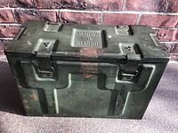 Closed metal army box with embossed markings 'B166A II 1945 DHC' on the top, showing wear and rust spots.