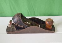 Side and top view of Stanley No. 22 hand plane showing metal body with wood knob and handle, surface rust, and adjustment mechanism.