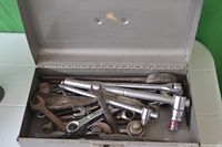 Open view of the toolbox showing assorted hand tools including wrenches and socket wrench extensions inside the box.