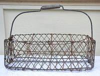 Wire milk carrier with wooden handle showing rectangular shape and wire lattice construction