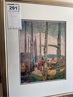 Framed print of Emily Carr artwork showing scene with totem poles and houses, framed in light wood frame with white matting.