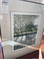 Framed print of canal scene showing full artwork in slim silver frame with double mat
