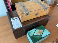 Three boxes stacked: two wooden boxes and one stained glass box.