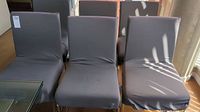 Six dining chairs in a row, chrome legs visible, gray seat covers on each seat and backrest with some spots and wear visible.