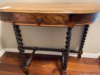 Full view of wood entry table with spindle legs and attached drawer closed.