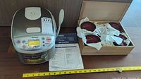 Top view showing rice cooker, paddle, manual, wooden box with bowls