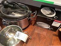 Photo showing Hamilton Beach slow cooker with glass lid and ladle, Ken Kostick pot, and boxed Typhoon bamboo steamer