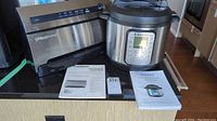 Foodsaver V3800 vacuum sealer and Instant Pot cooker shown with manuals on a countertop