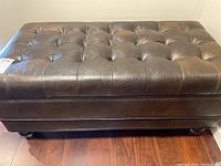 Full view of rectangular tufted vinyl storage bench showing the top and base structure.