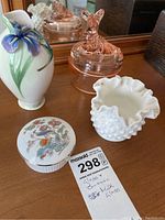 All four items including a pink glass covered dish with dog figure lid, Fenton white milk glass hobnail vase, Franz iris flower vase and Wedgewood floral dish.