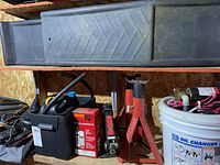 Photo showing two black automotive creepers with cushioned tops, highlighting item condition and detail.