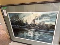 Full view of framed watercolor painting leaning against wall