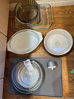 Top-view of entire ovenware set showing glass dishes, white ceramic dish with lid, metal baking trays stacked, and timer