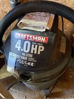 Top view of Craftsman shop vacuum showing 4.0 HP rating and 45 litre capacity with hose coiled on top and manual on top of the unit.
