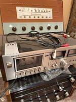 Stacked components with decorative panel, cassette deck and amplifier visible, cables on top