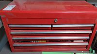 Front view of the red metal toolbox showing the drawer handles and overall size