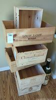 Six stacked wooden wine crates with visible brand names Louis Jadot and Château Fontenil