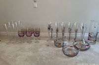 Full lot showing wine glasses, flutes, pitcher, ice bucket, and vase arranged on floor.