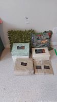 Full view of all items in lot including king duvet cover, pillow shams, and three sheet sets in packaging.