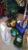 Overview of lot showing pressure washer, spreader, fertilizer bag, weed killer container, bins and net