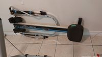 Full side view of the West Bend 5200 rowing machine showing padded seat and foot rests on tiled floor.