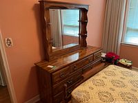 Full front view of the wood dresser with mirror showing the finish, drawers, and mirror reflection.