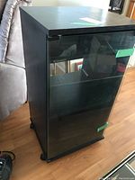 Front left angle view of the Pioneer stereo cabinet showing glass door and internal shelving.