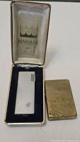 Zippo and Marouis vintage lighters side by side with Marouis case visible